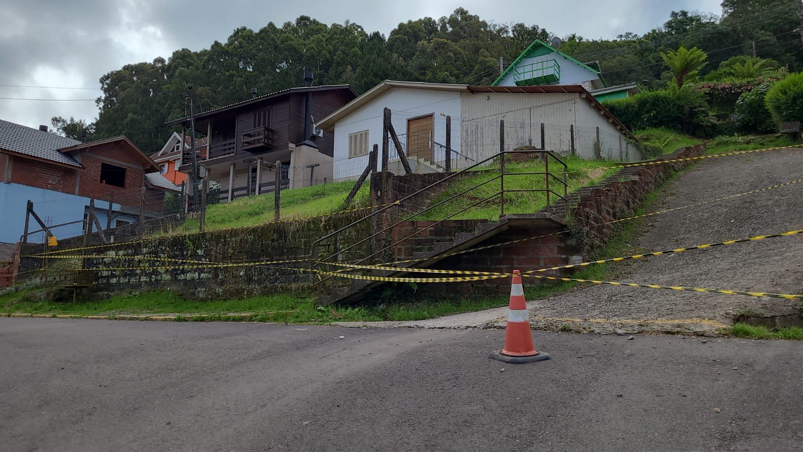 Uma casa está situada no topo de uma colina perto de uma estrada.