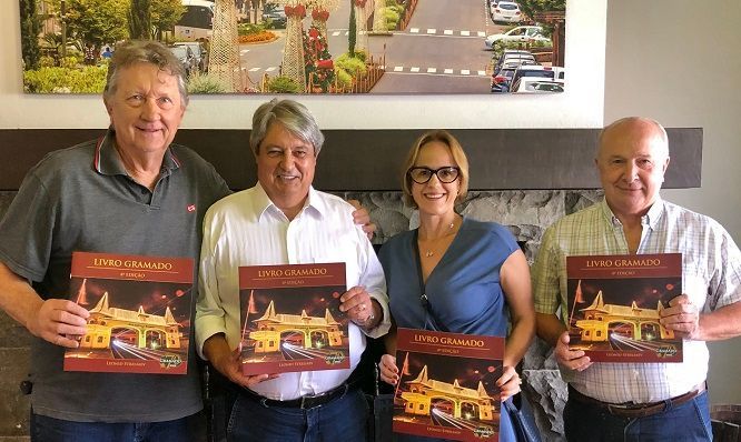 Um grupo de pessoas está próximo um do outro segurando livros.
