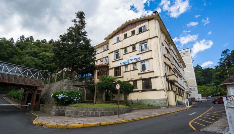 Um grande edifício está situado na esquina de uma rua.