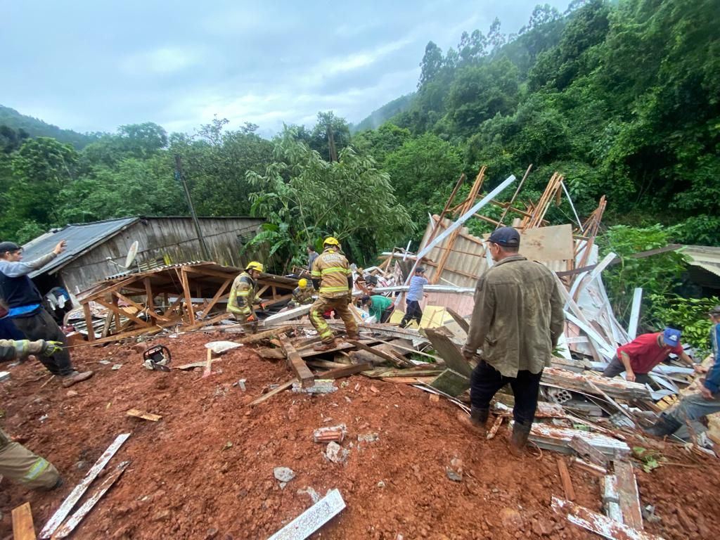 Um grupo de pessoas está em cima de uma pilha de escombros.