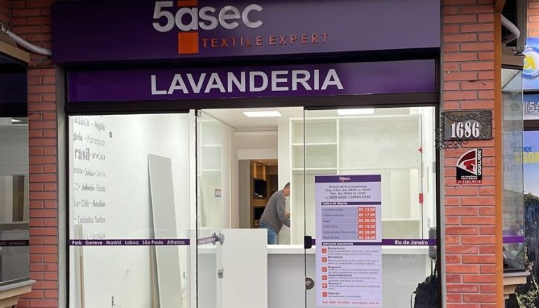 Uma lavanderia com uma placa roxa que diz 5asec lavanderia