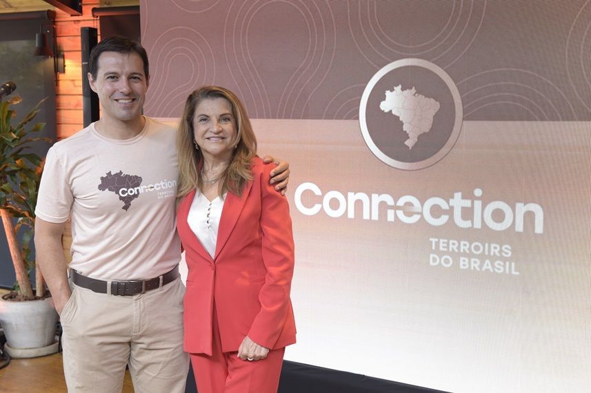 Um homem e uma mulher posam para uma foto em frente a uma placa de conexão.