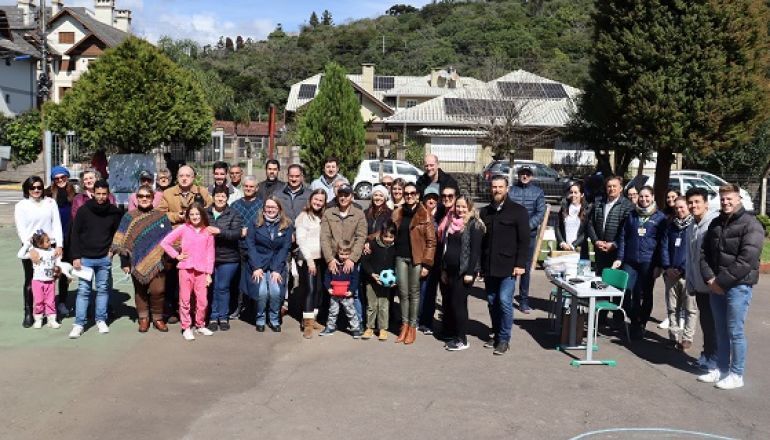 Um grande grupo de pessoas posa para uma foto em um parque.