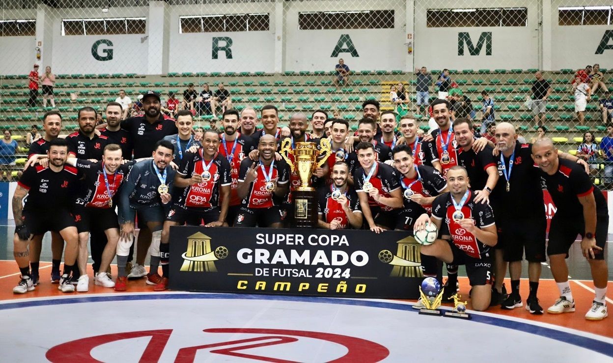 Um grupo de jogadores de futebol posa para uma foto com um troféu.