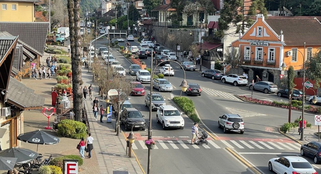 Uma vista aérea de uma rua movimentada da cidade com carros passando por ela.