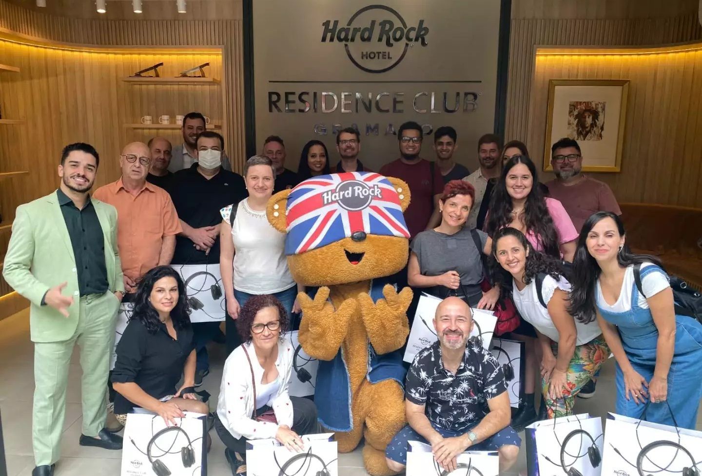 Um grupo de pessoas posa para uma foto com um mascote.