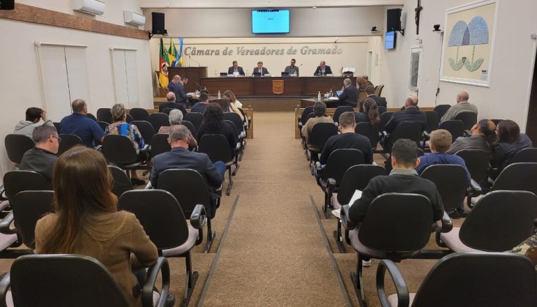 Um grupo de pessoas está sentado em cadeiras em uma sala de conferências.