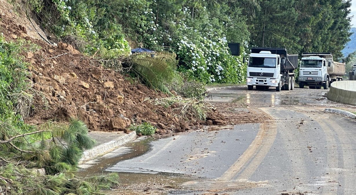 Um caminhão está dirigindo por uma estrada próximo a uma grande pilha de pedras.