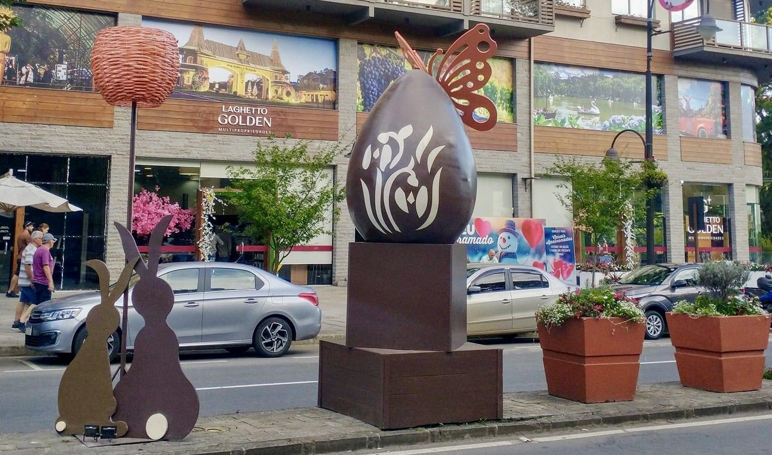 Um grande ovo de chocolate com uma borboleta está na beira da estrada.