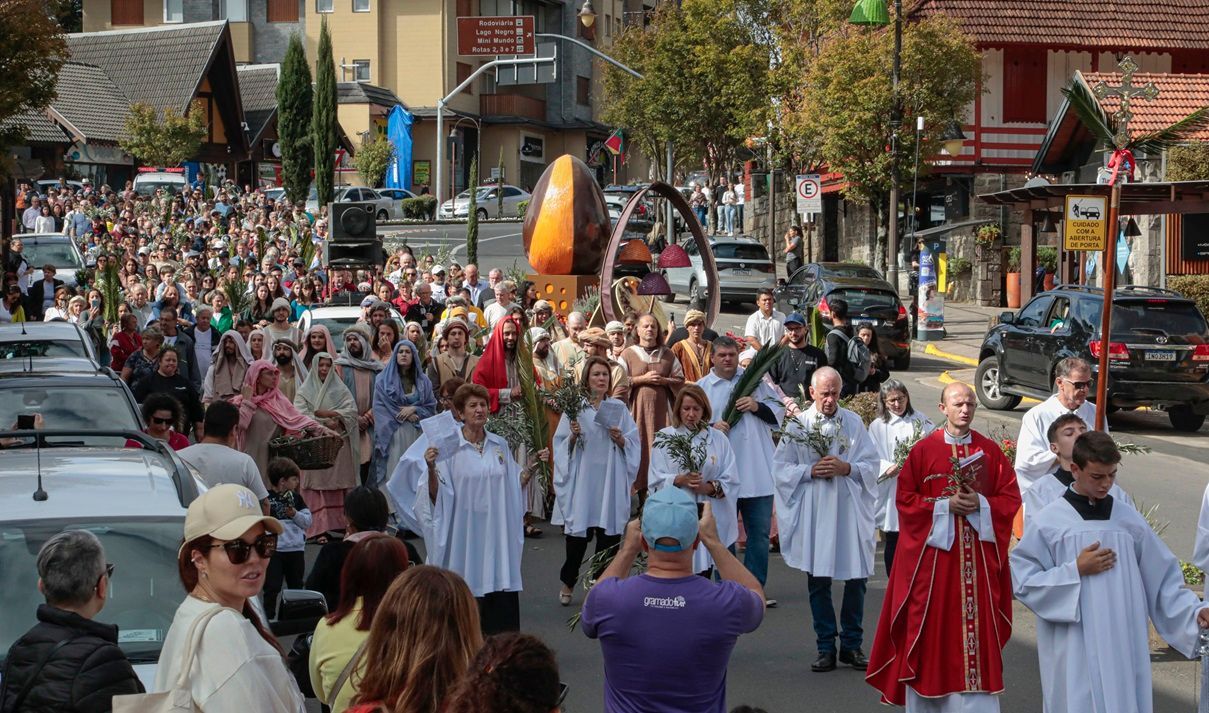 Um grande grupo de pessoas está andando por uma rua.