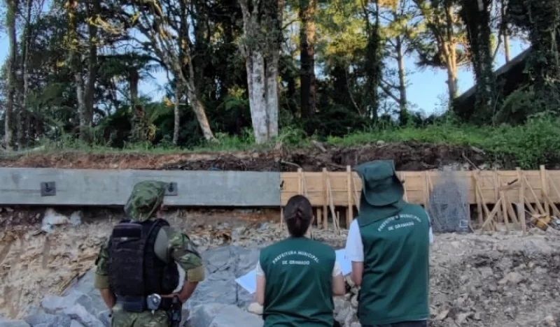 Um grupo de pessoas próximas umas das outras em frente a uma floresta.