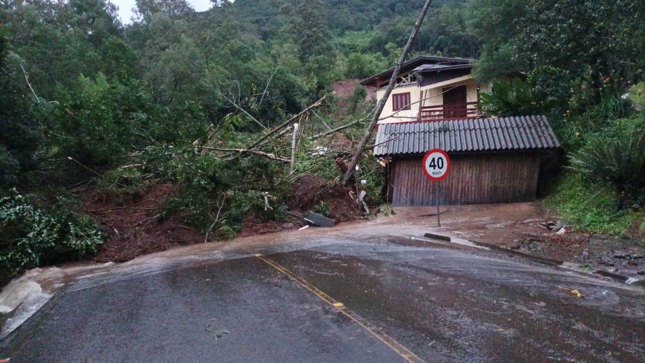 Uma casa está situada no topo de uma colina perto de uma estrada.