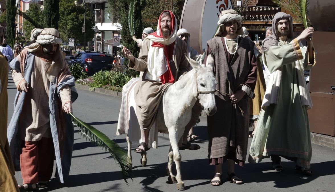Jesus está montado em um burro em um desfile.