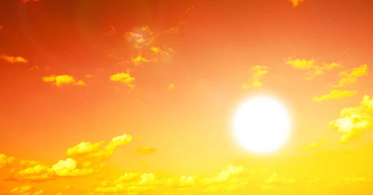 A bright and sunny day where the sky forms an orange gradient. Some light clouds roll across the landscape.