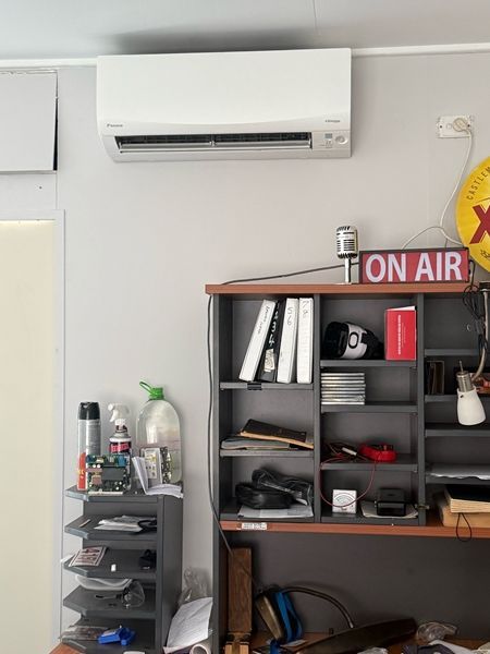 Air Conditioner Above a Desk With Shelves Holding Items — BNS Refrigeration Services in Healy, QLD