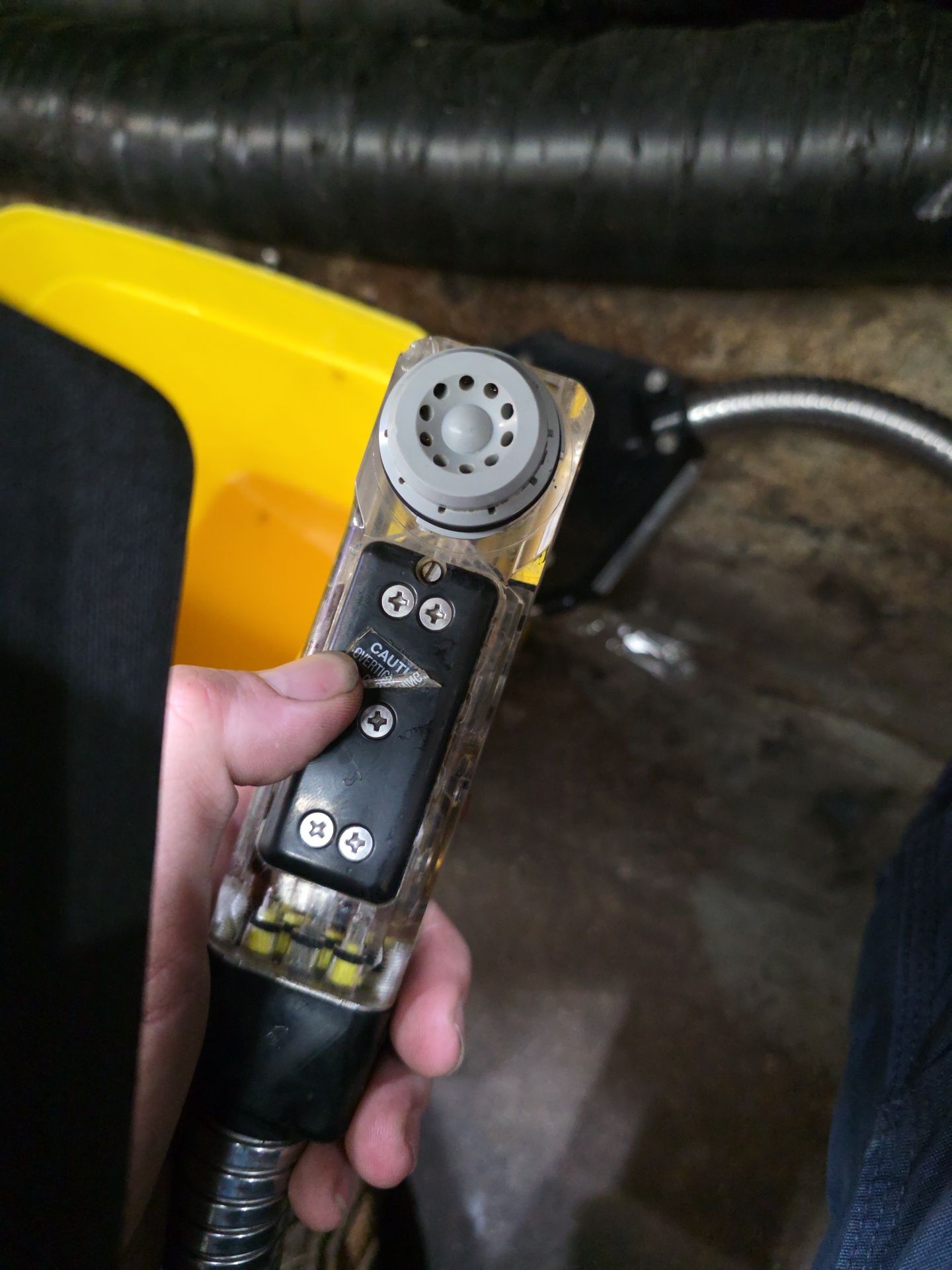 Hand Holding a Yellow and Black Device — BNS Refrigeration Services in Healy, QLD