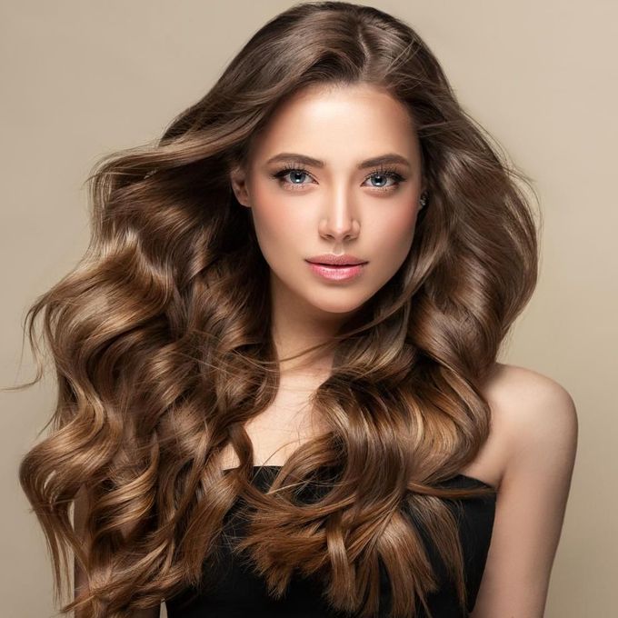 A Woman With Long Brown Hair is Wearing a Black Dress — Sophisticut Hair Salon in Mysterton, QLD