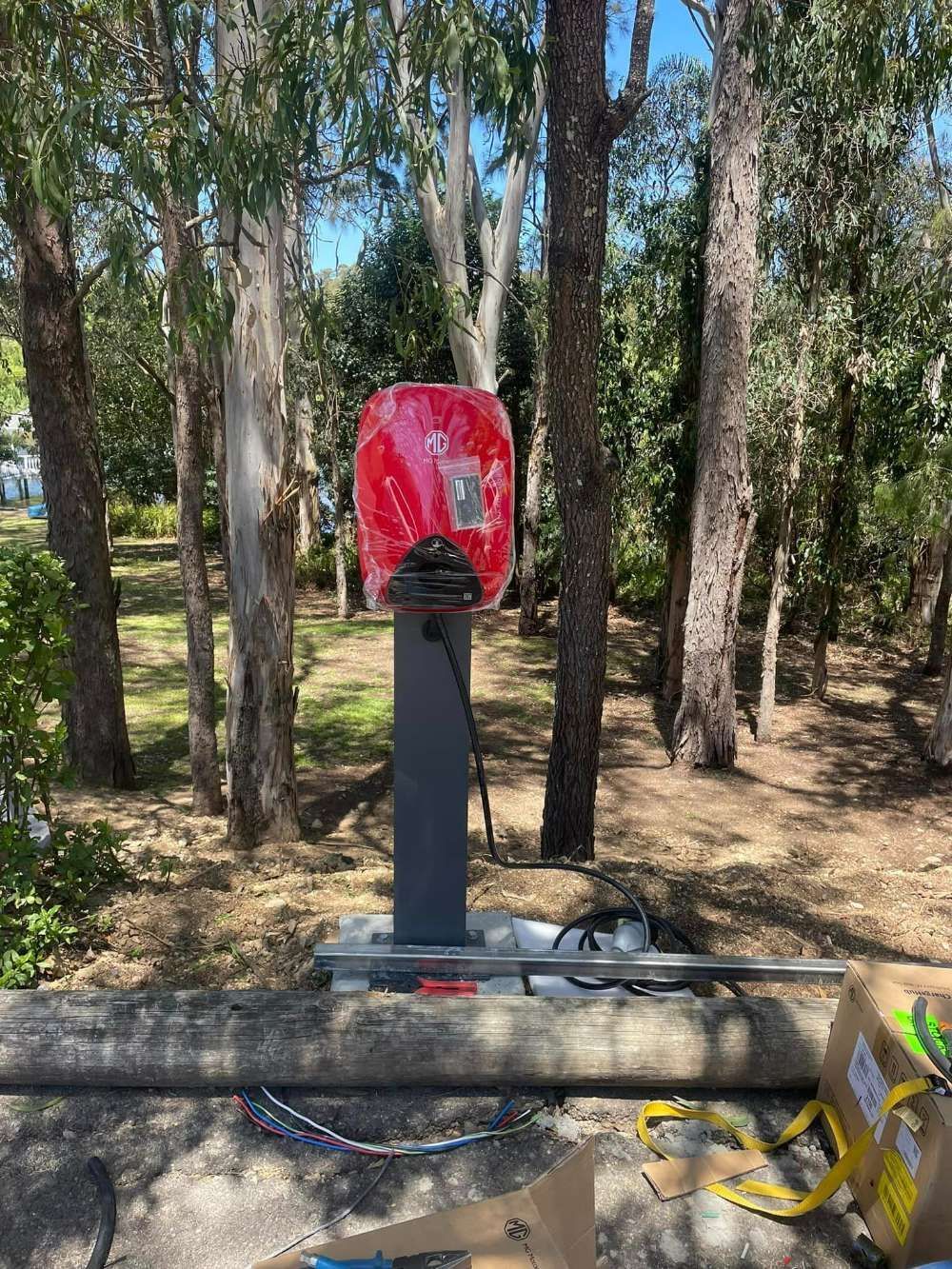 A Red Telephone Booth Is Sitting In The Middle Of A Forest — BayCoast Electrical & Control Solutions in Ulladulla, NSW