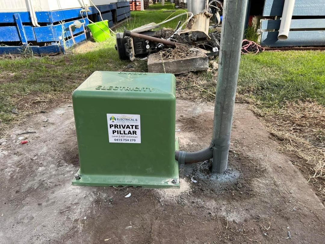 A Green Box Is Sitting Next To A Pole In The Dirt — BayCoast Electrical & Control Solutions in Maloneys Beach, NSW