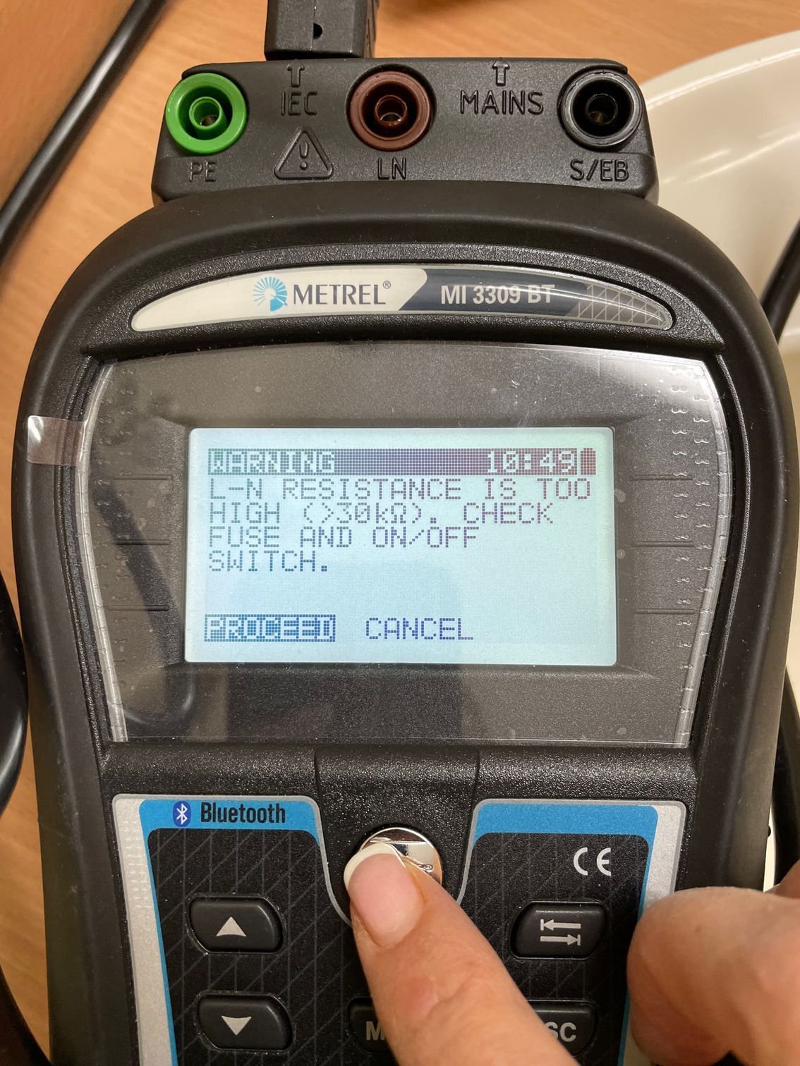 A Person Is Using A Multimeter To Test A Plug — BayCoast Electrical & Control Solutions in Ulladulla, NSW