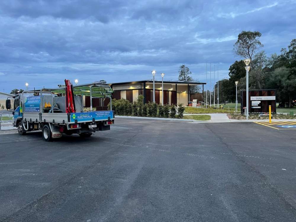 Two Trucks Are Parked In A Parking Lot In Front Of A Building — BayCoast Electrical & Control Solutions in Maloneys Beach, NSW