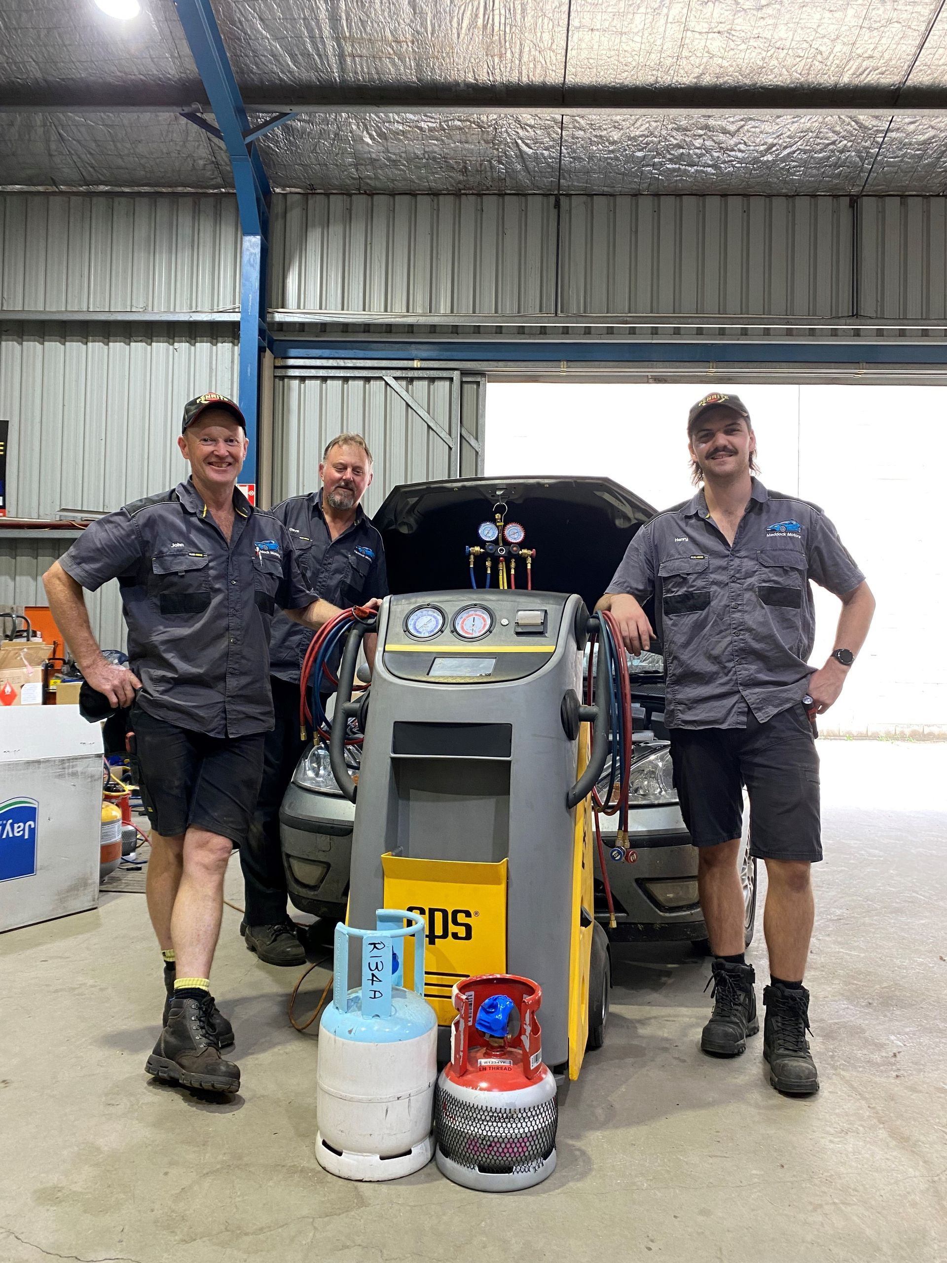 Three Mechanics in Uniform Pose in a Garage — Maddock Motors-Wodonga Auto Air In Wodonga, VIC