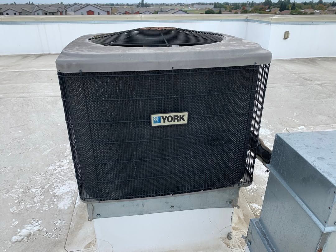York rooftop HVAC unit with black grille and fan on a concrete roof