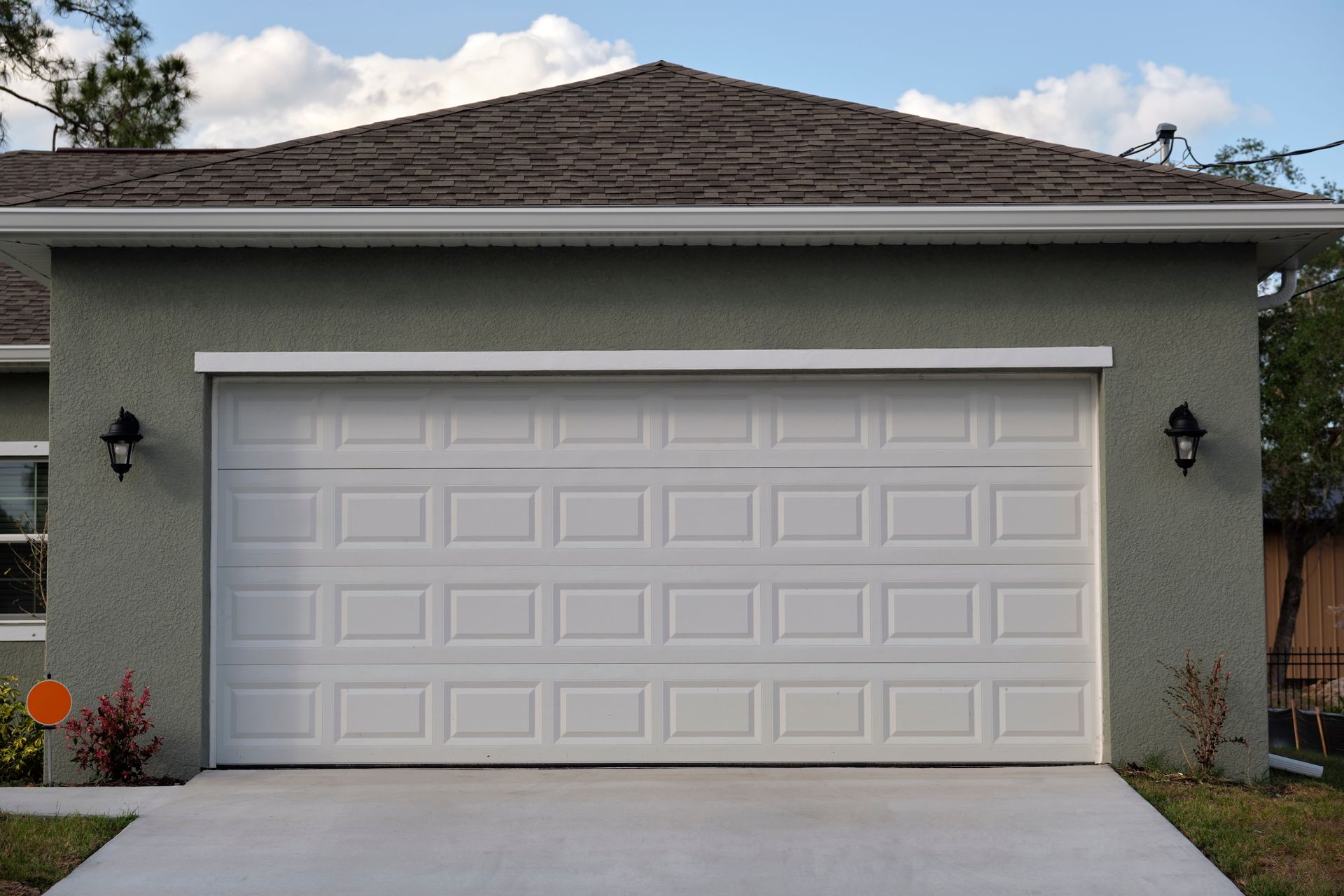 White raised-panel garage door on a stucco home with attached garage.