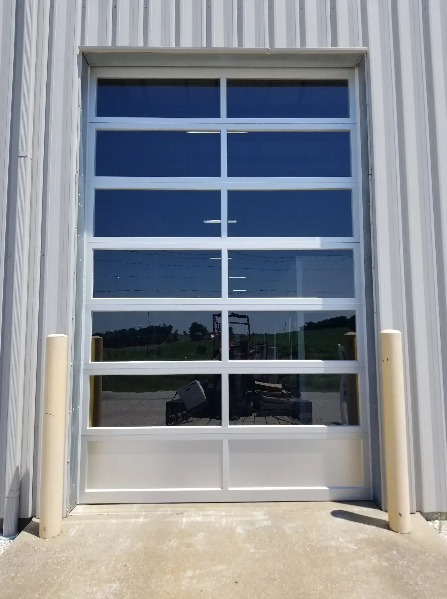Glass industrial door with blue-framed panes on a corrugated metal building
