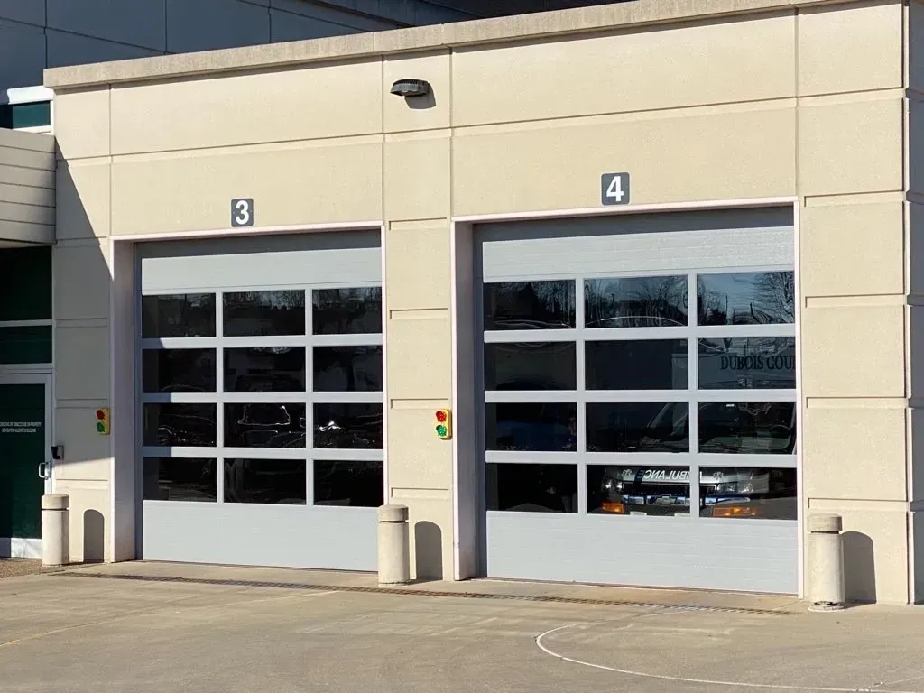 Two beige garage bay doors labeled 3 and 4 on a commercial building