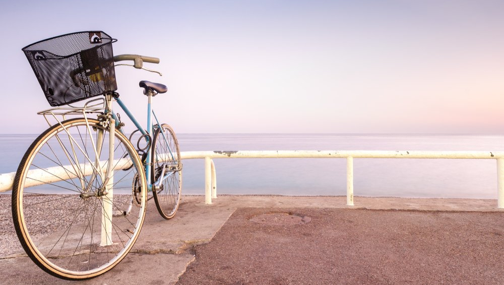 Old bike parked next to the beach