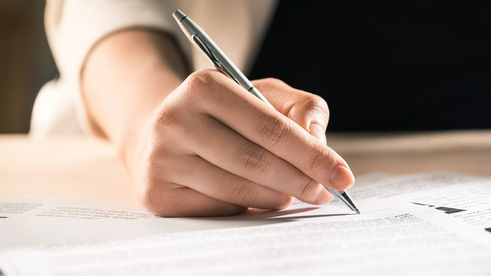 woman signing a document
