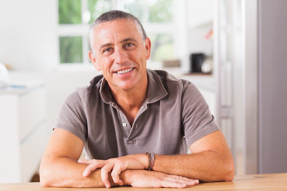 Older man sitting on at his kitchen table