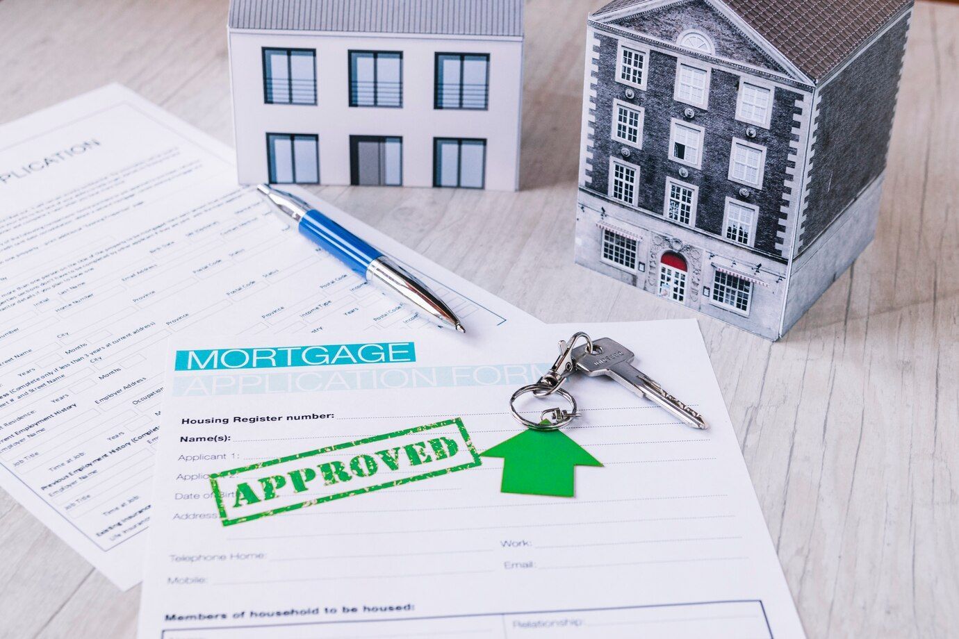 A model house is sitting on top of a piece of paper that says approved.