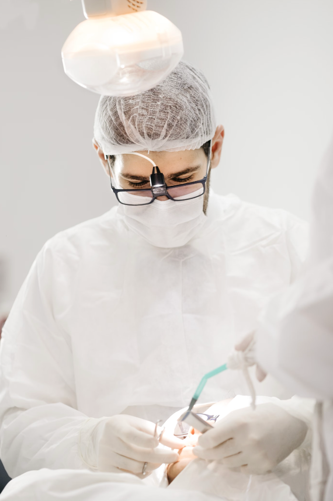 A dentist is working on a patient 's teeth in a dental office.