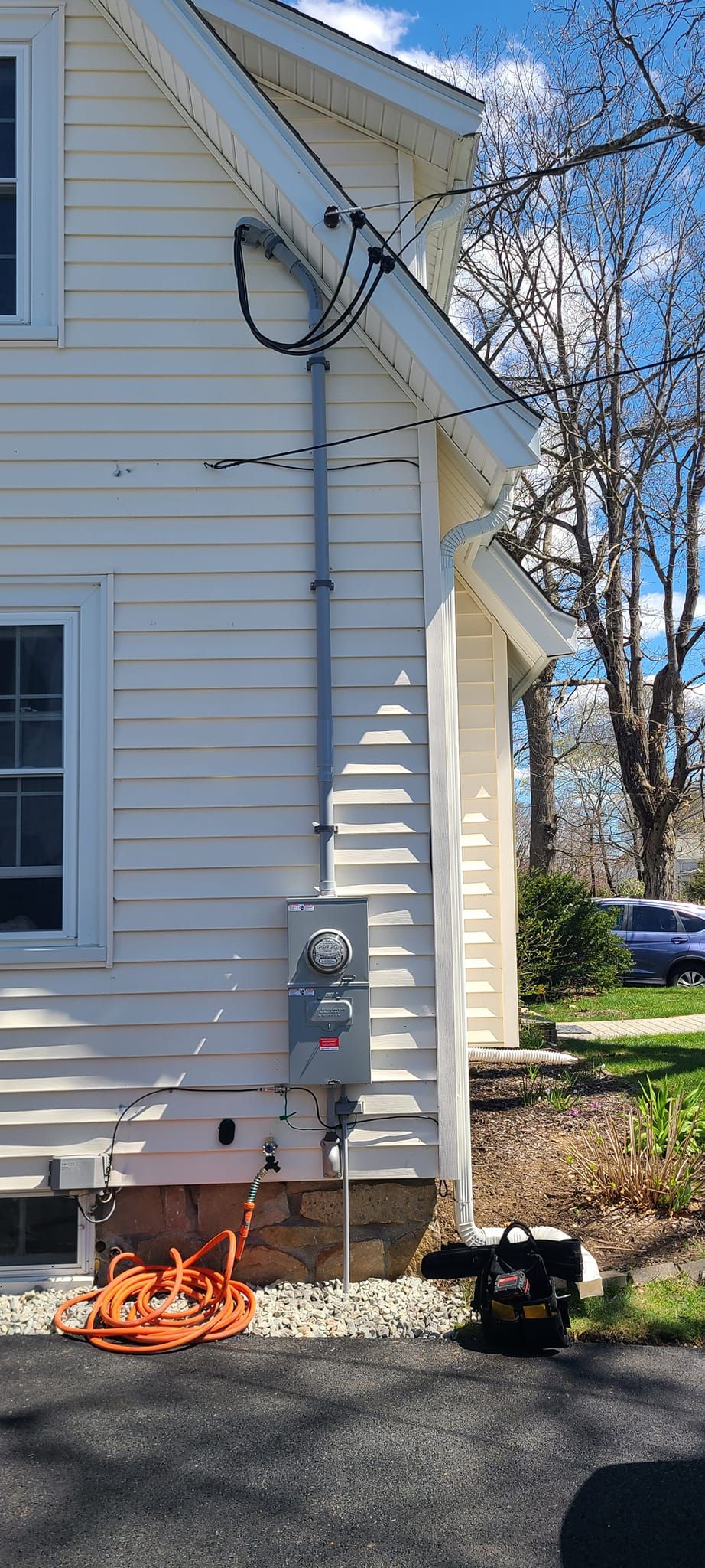 House side with utility meter and orange flames burning at the base near the driveway