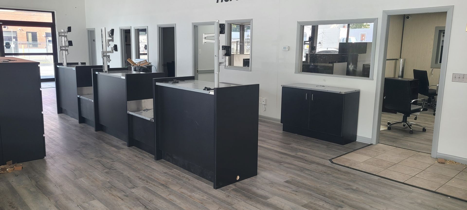Modern salon interior with black stations, mirrors, and wood flooring
