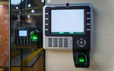 Biometric security device with an LCD screen, keypad, and fingerprint scanner mounted on a wall.