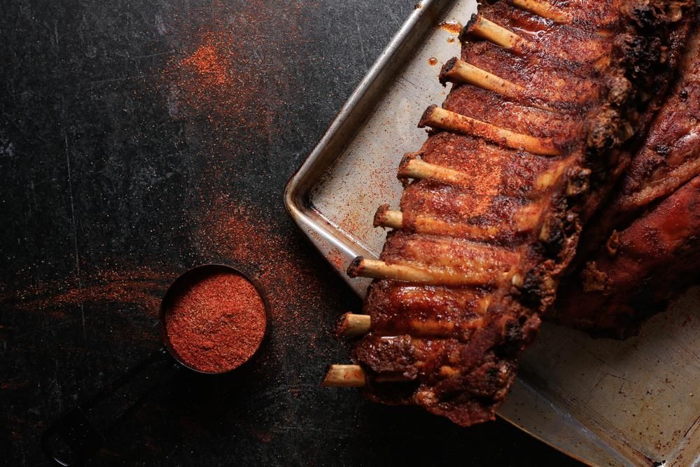 A Tray Of Ribs And A Measuring Cup Of Seasoning On A Table — Edgeworth Meat & More in Edgeworth, NSW
