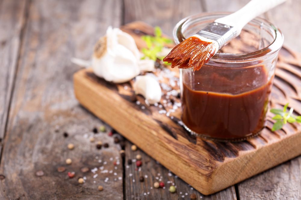 A Jar Of Barbecue Sauce With A Brush On A Wooden Cutting Board — Edgeworth Meat & More in Edgeworth, NSW