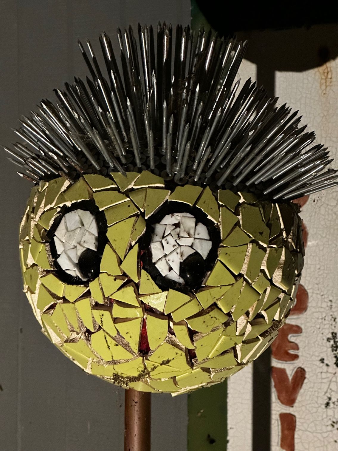 A smiley face made out of broken cds with a mohawk