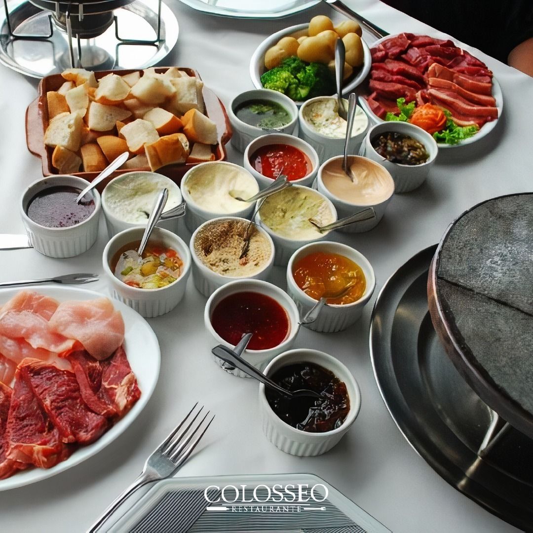 Uma mesa coberta com pratos de comida e tigelas com molhos fondue Gramado Serra Gaúcha