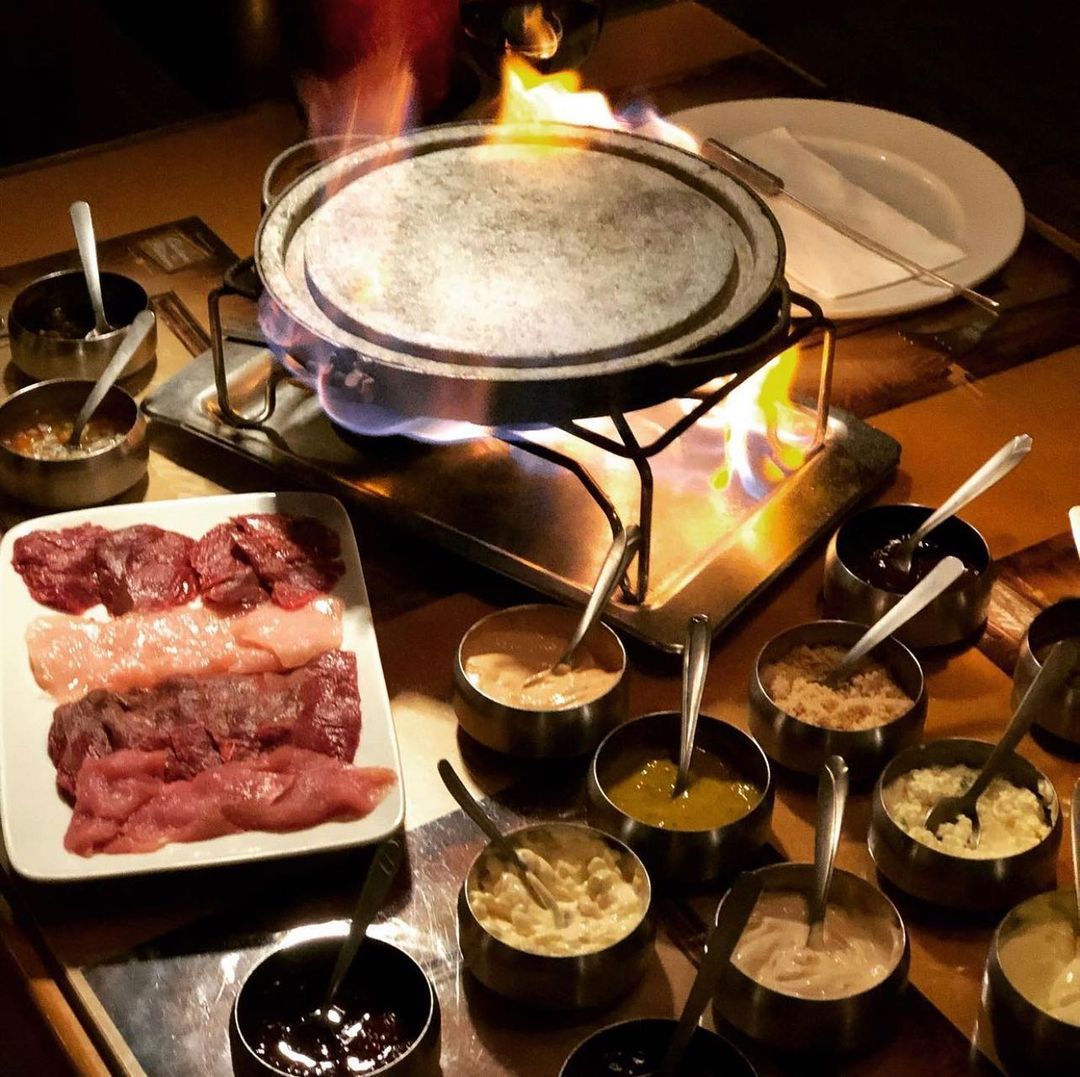 Uma mesa coberta com pratos de comida e tigelas de molhos Gramado Serra Gaúcha