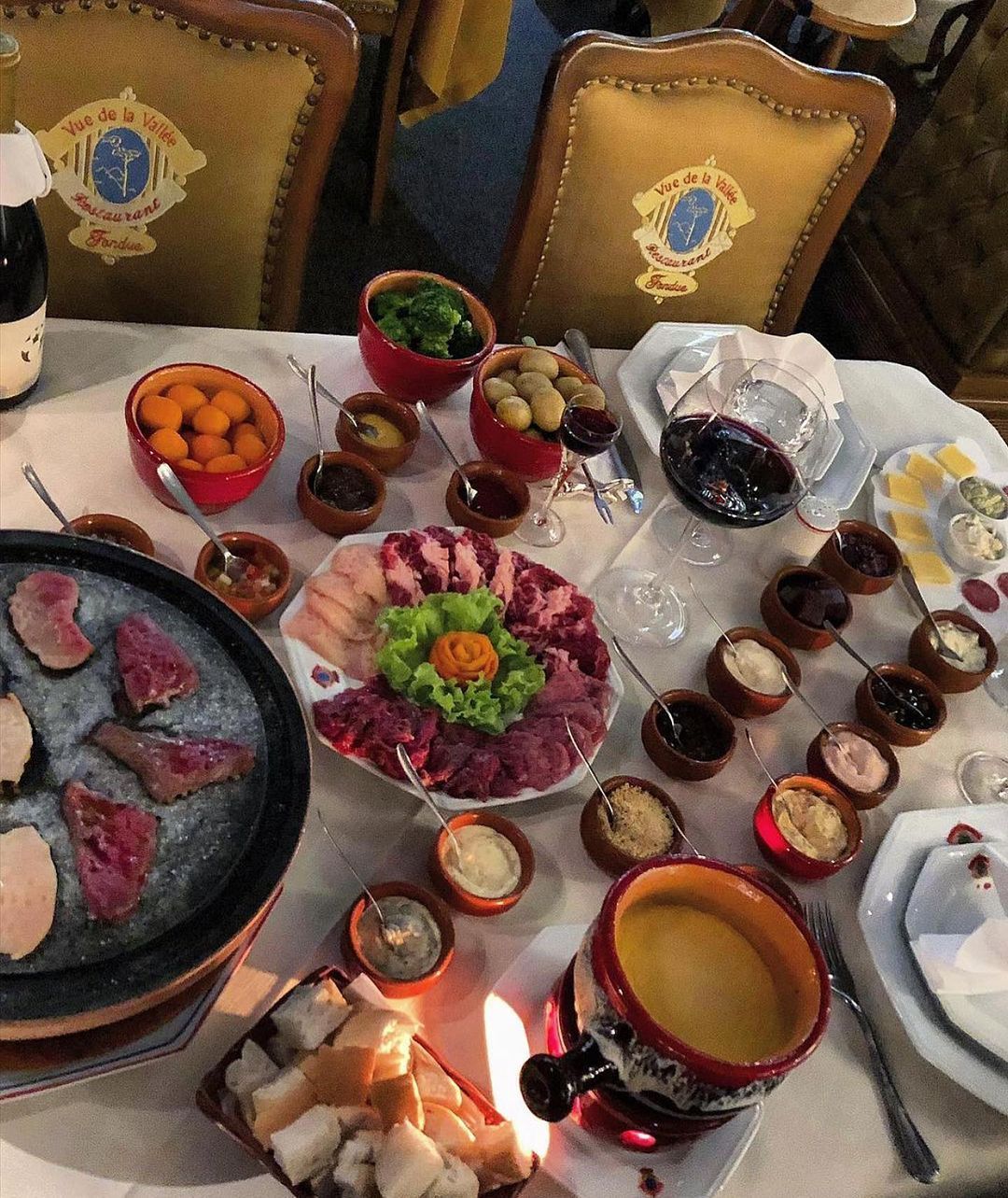 Uma mesa com muita comida, incluindo uma panela de fondue Gramado Serra Gaúcha