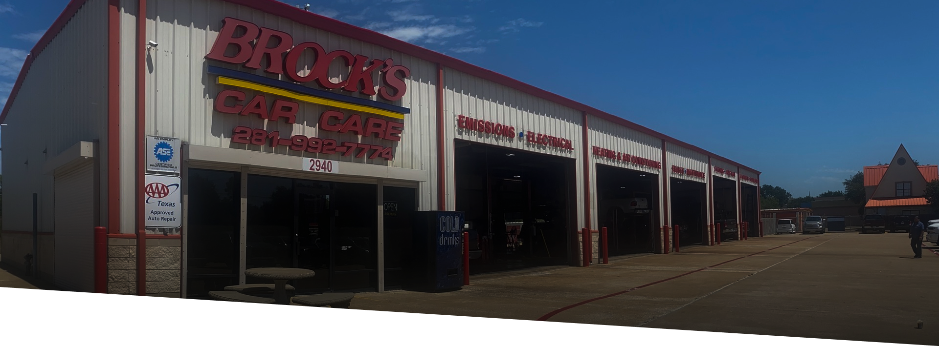 A beige, multi-bay auto repair shop named Brown's Car Care Center under a bright blue sky.