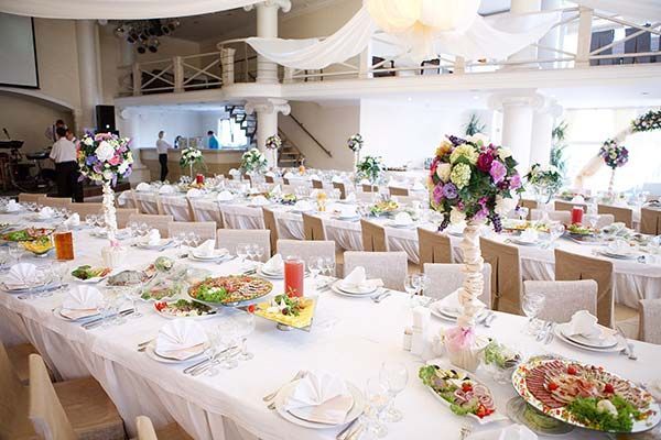 A large room filled with tables and chairs and plates of food.