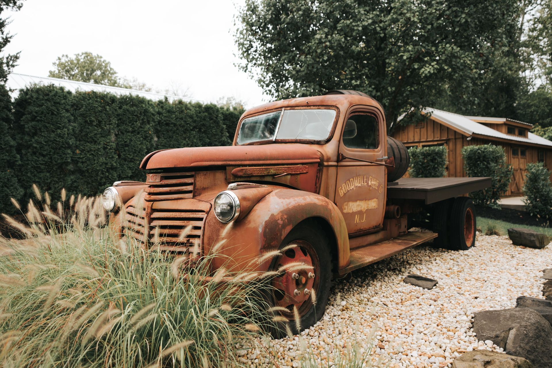 A rusted older pickup parked in tall grass, the kind of vehicle that moves a few times a year