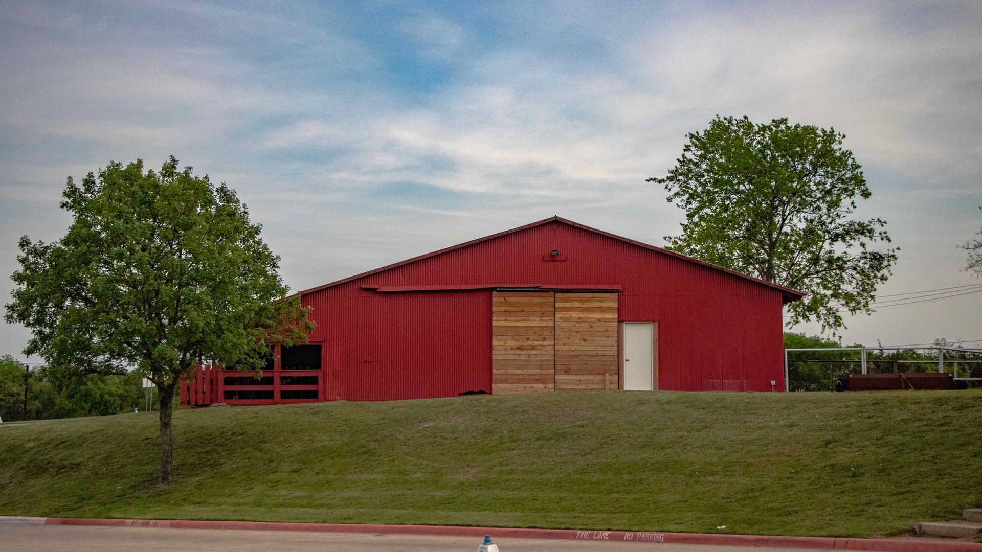 Red metal barn on a rural North Texas property, a detached structure insured under homeowners Covera