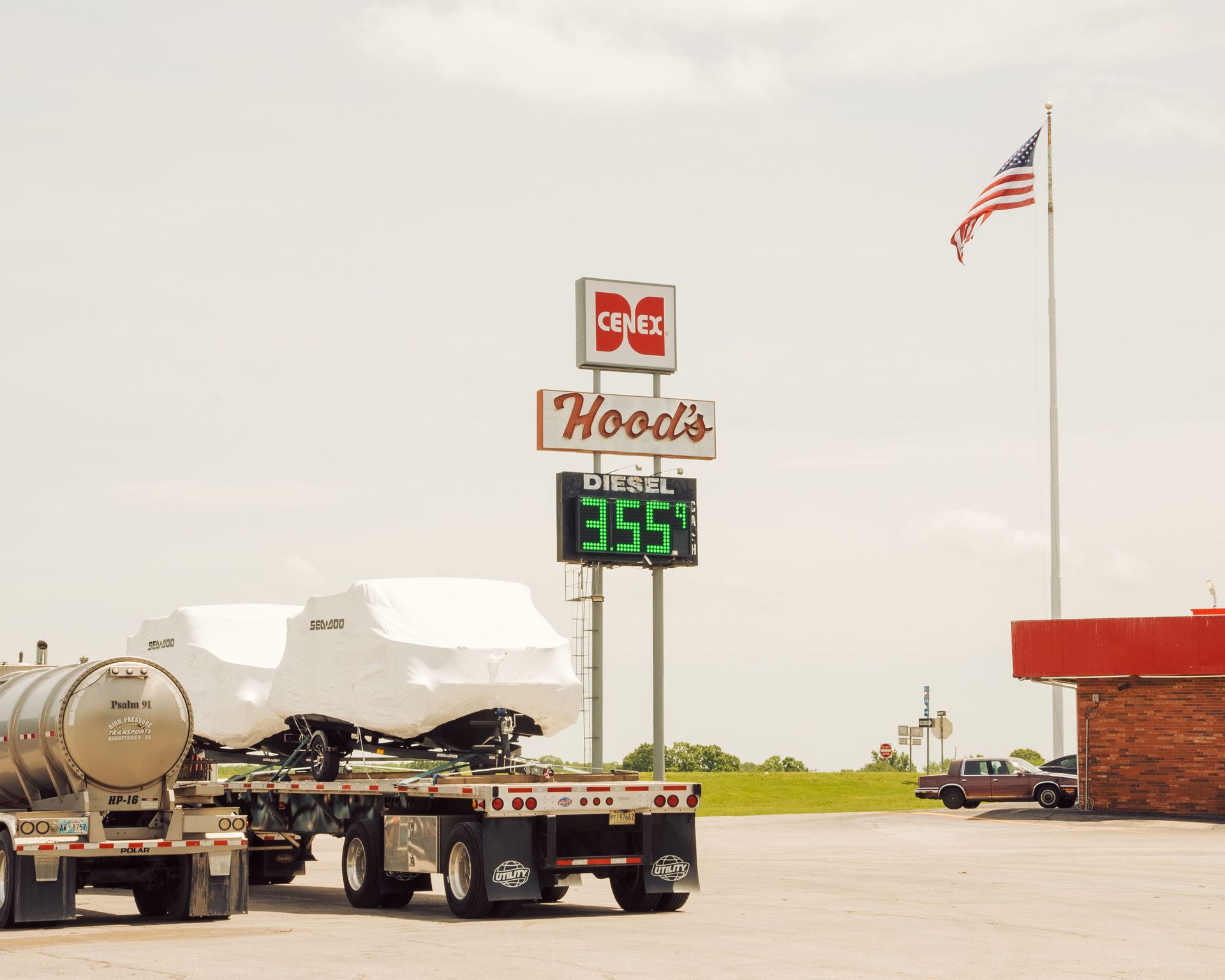 Truck driver checking paperwork on a phone at a North Texas fuel island while waiting