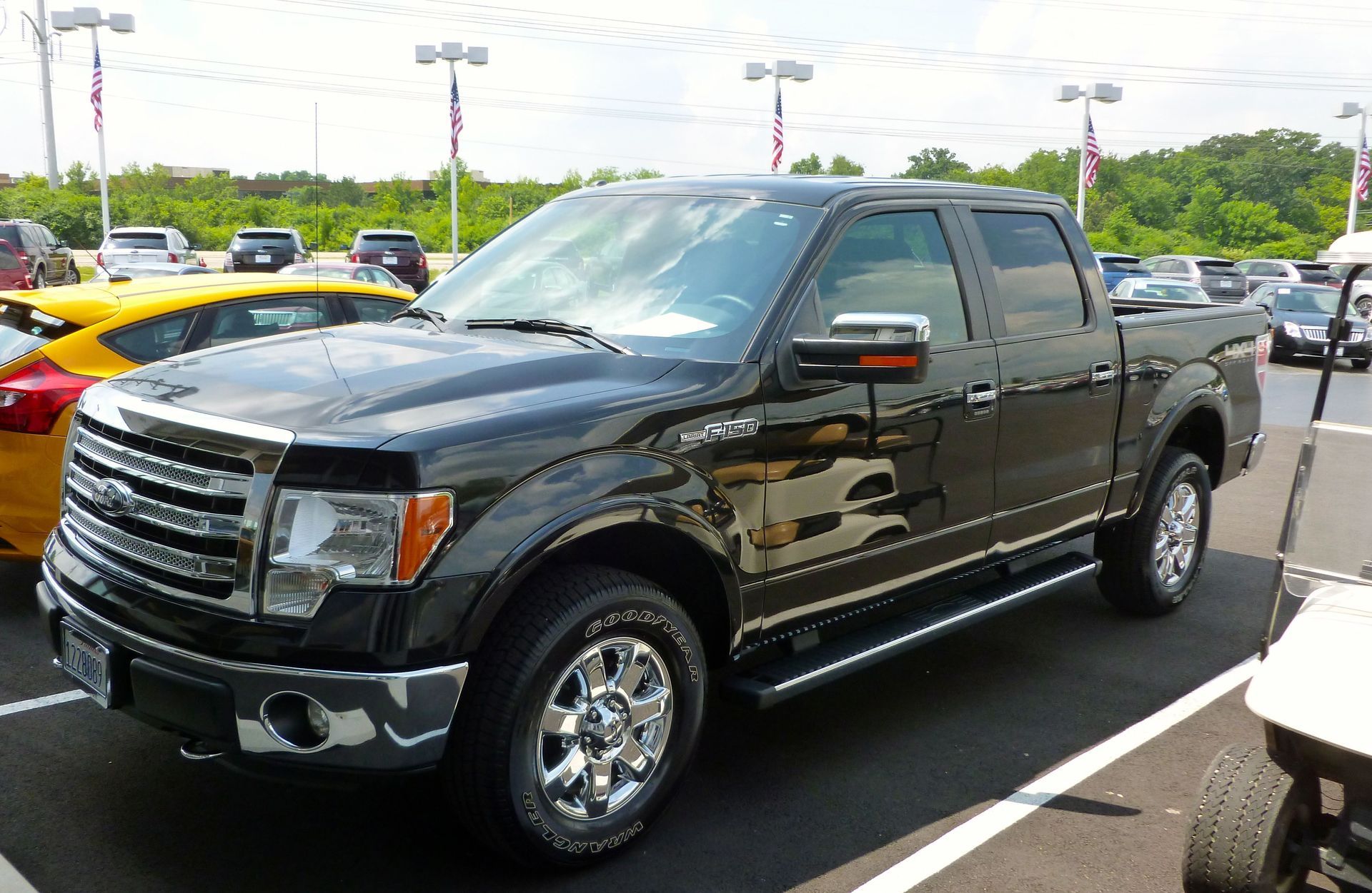 A black pickup parked on a dealership lot, where a repaired truck's accident history cuts its value